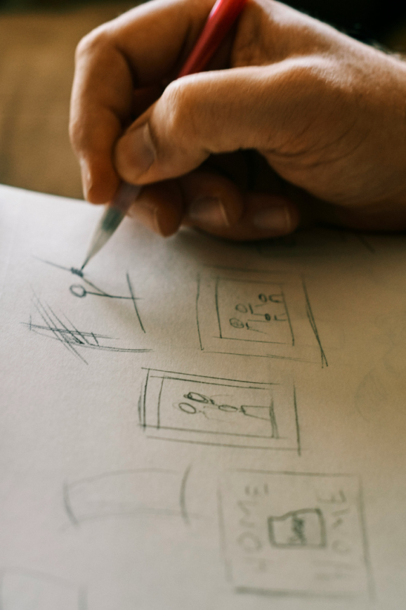Male hand holding a pencil above a sketchpad