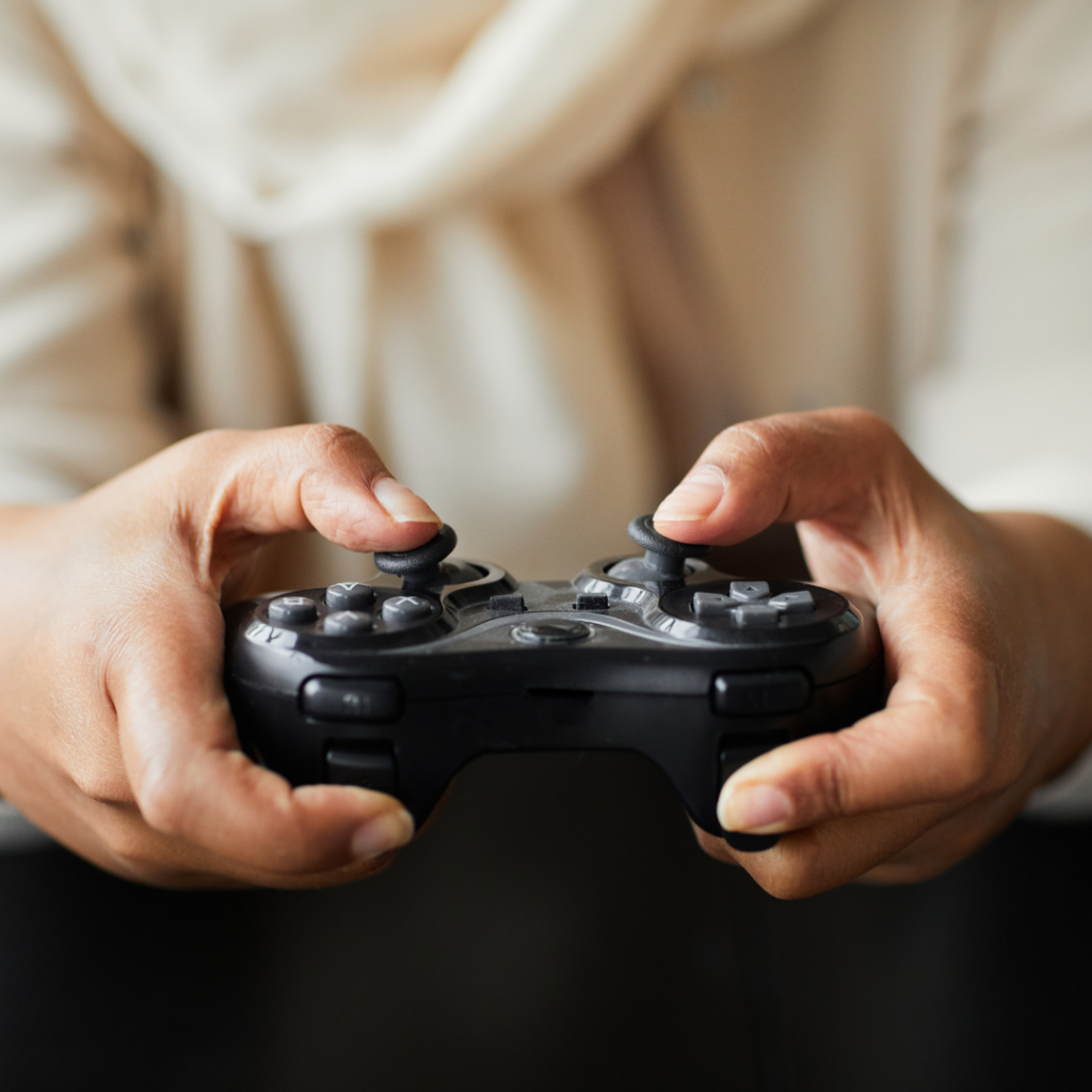 Hands holding black video game remote